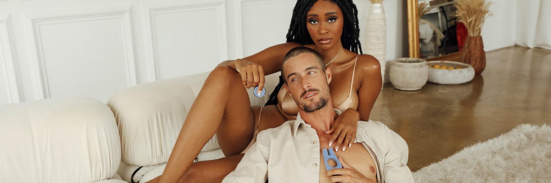 Couple lounging on cream sofa holding luxury wellness products by JIMMYJANE in modern living room