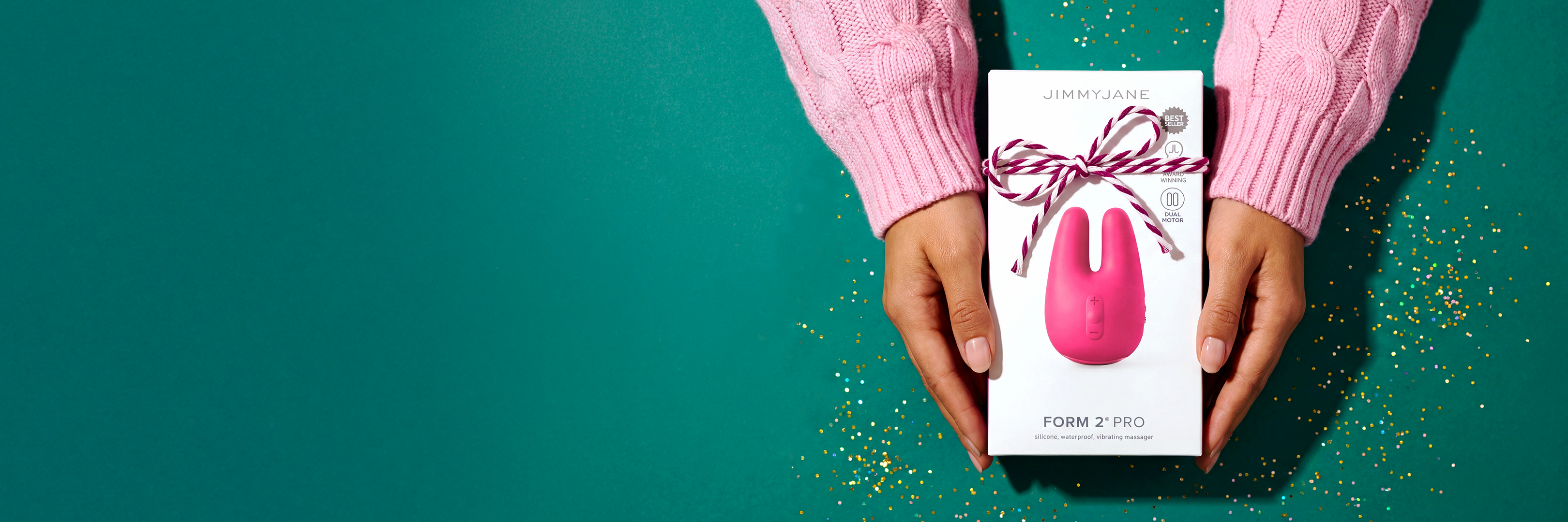 Person holding a pink toy with packaging against a teal background