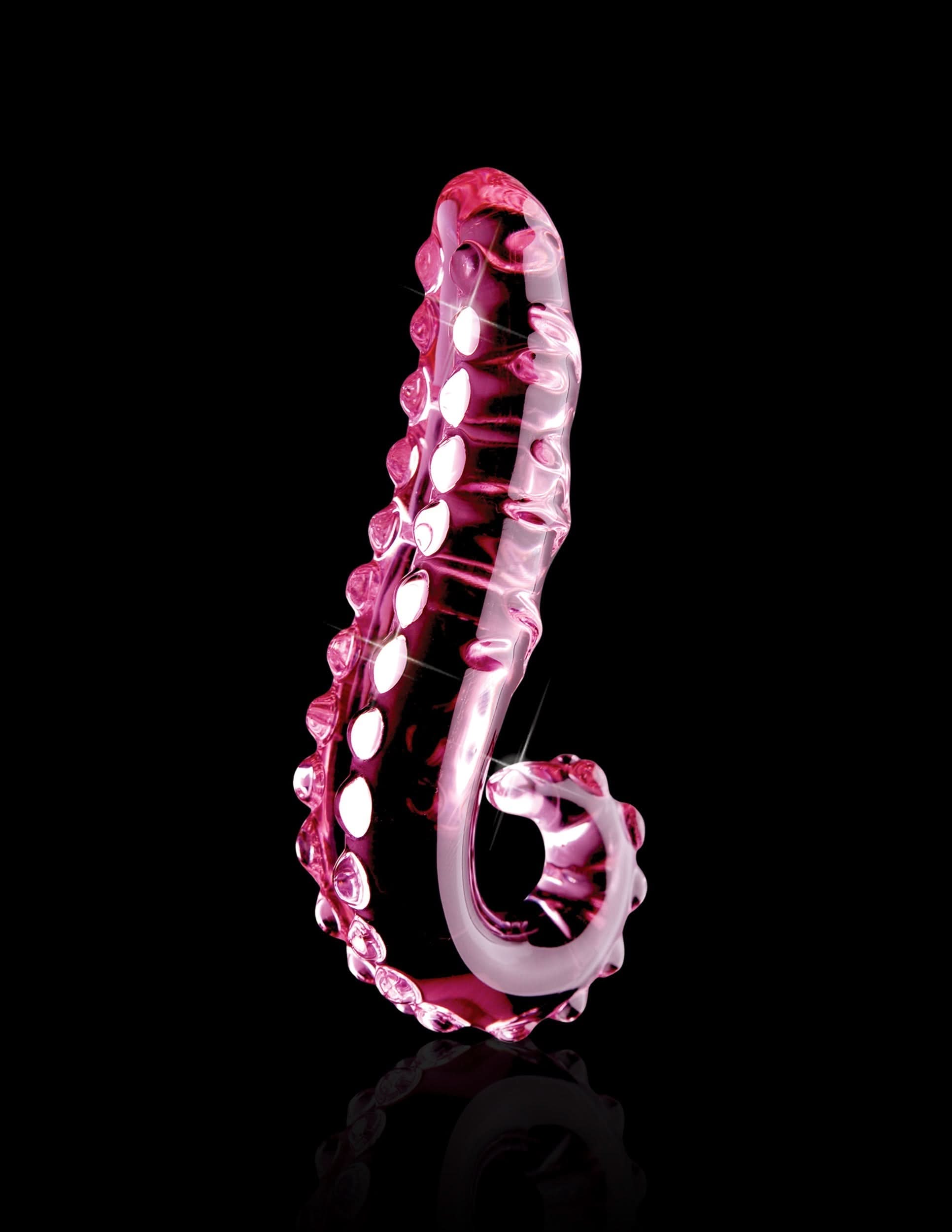 The Icicles® No. 24 by Icicles® is a pink hand-blown glass massager shaped like a curved tentacle with suction cup details, shown on a black background.