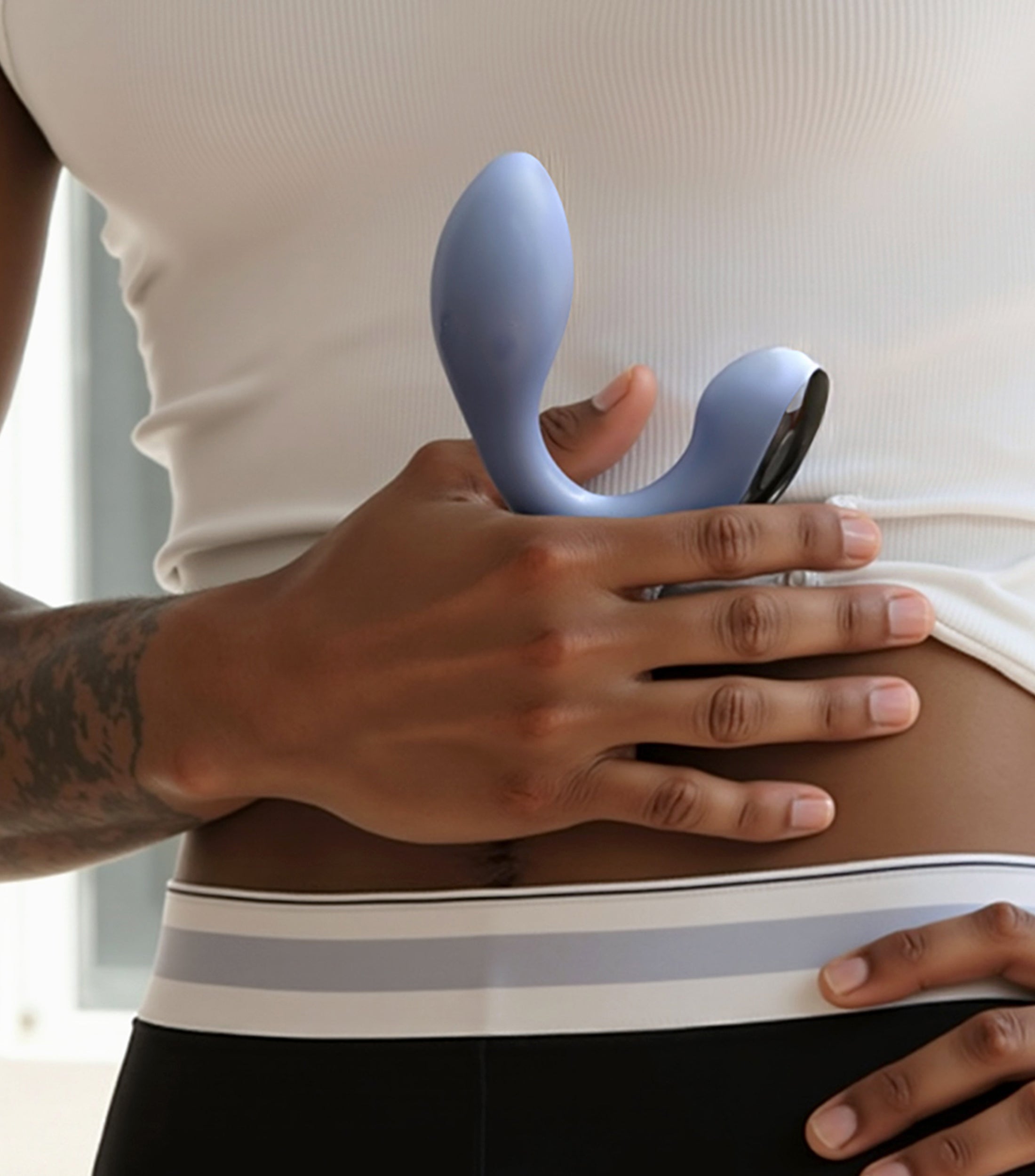 Person holding a blue and black electronic device against their stomach.