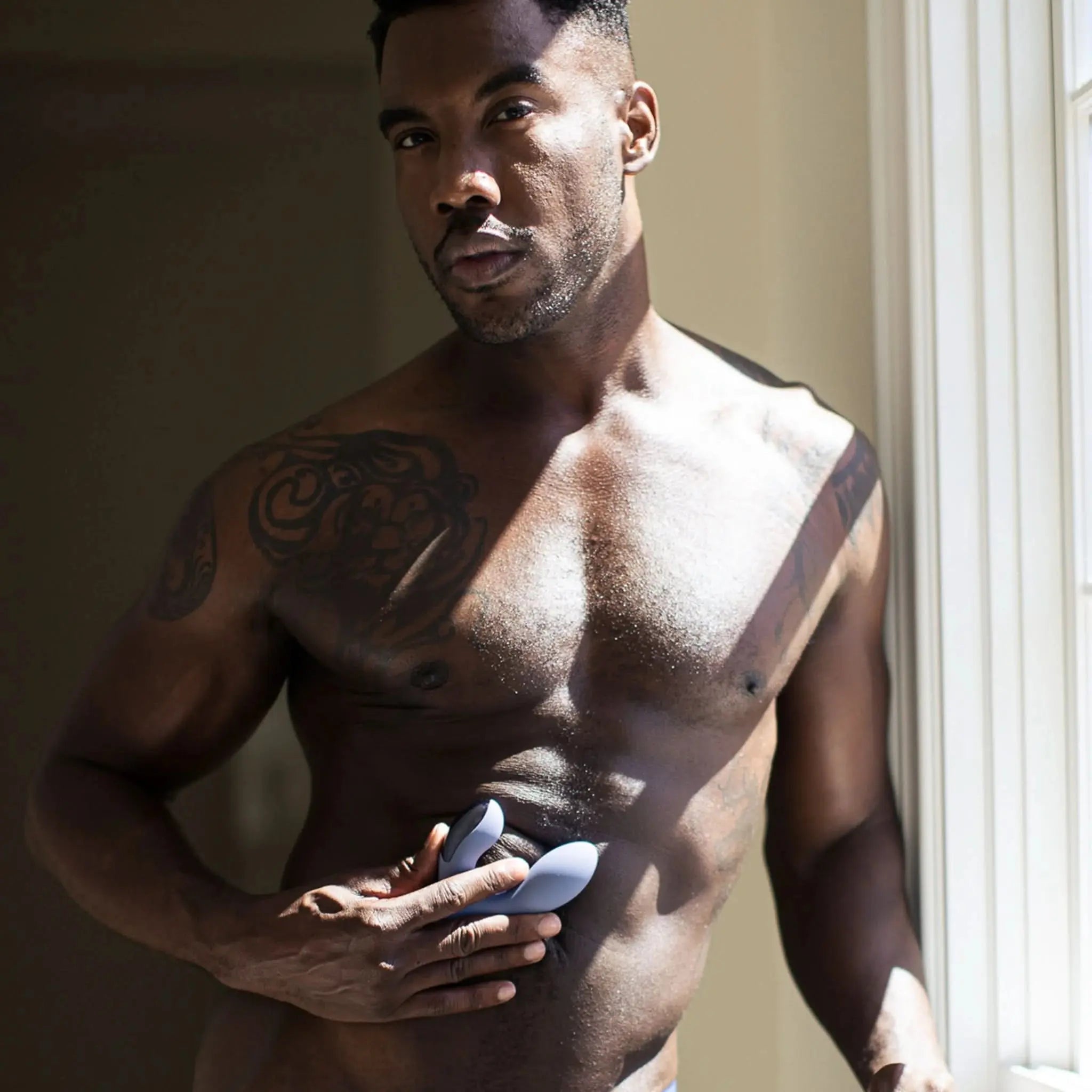 Man using a luxury wellness massager by JIMMYJANE near a sunlit window