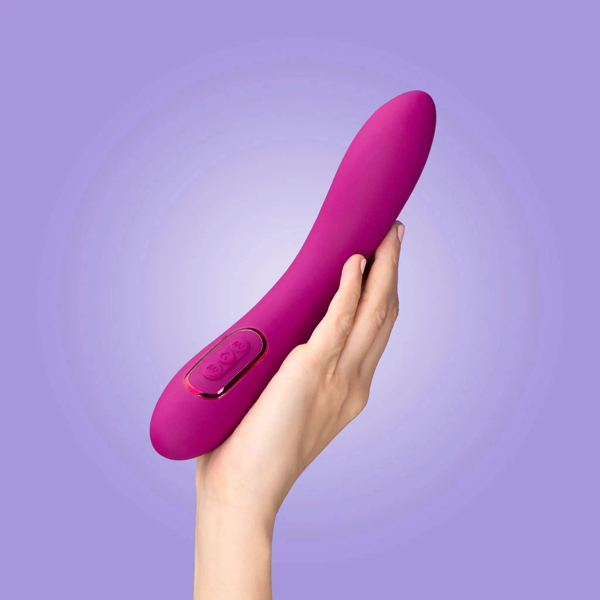 Hand holding a pink luxury personal massager by JIMMYJANE against a purple background