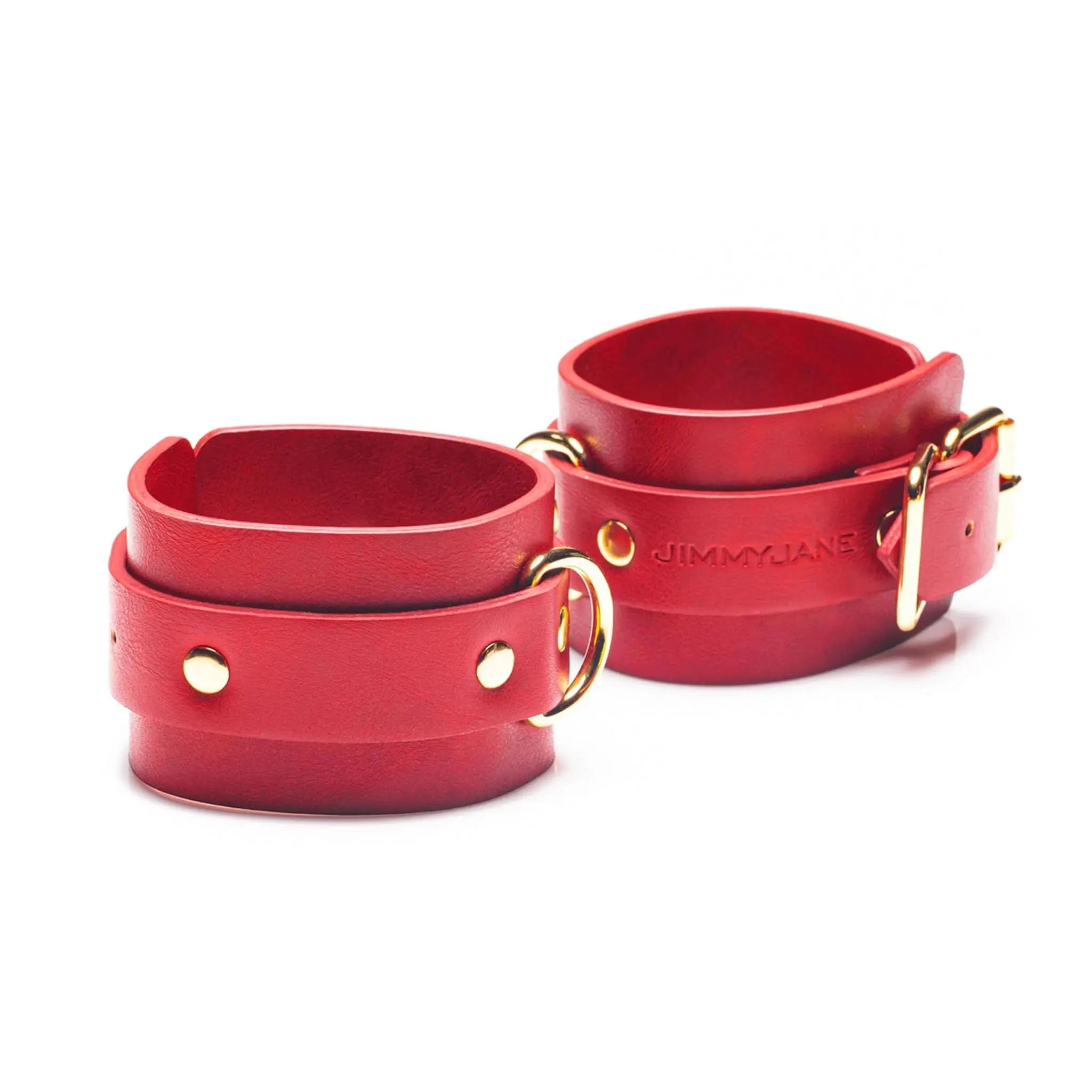 Red leather cuffs with gold hardware by JIMMYJANE on white background