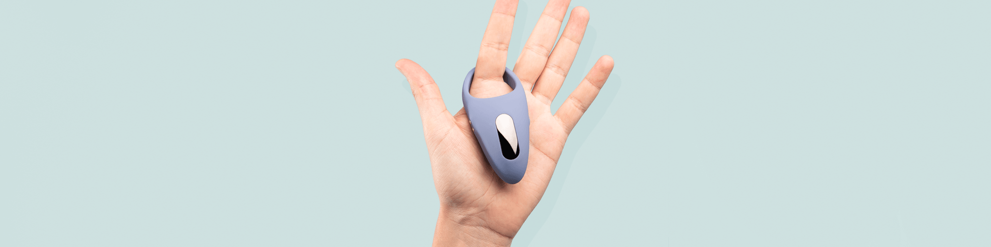 Hand holding a sleek blue luxury wellness device from JIMMYJANE against a pale background