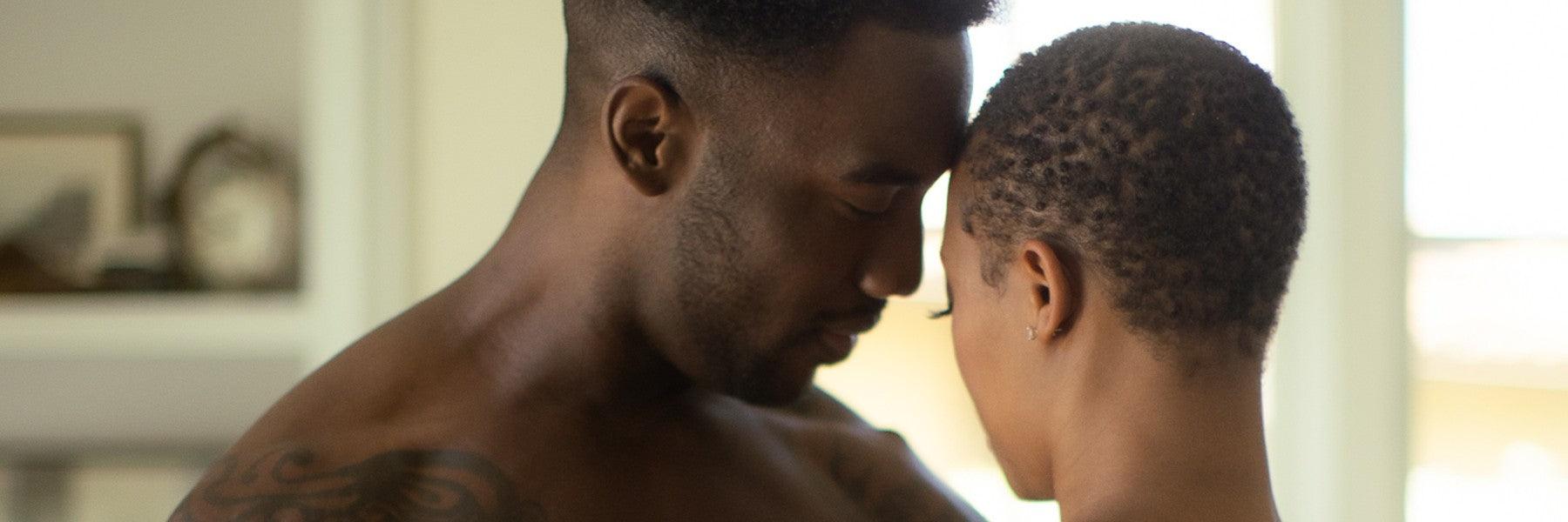 Intimate couple embracing in a softly lit room, promoting JIMMYJANE luxury lifestyle