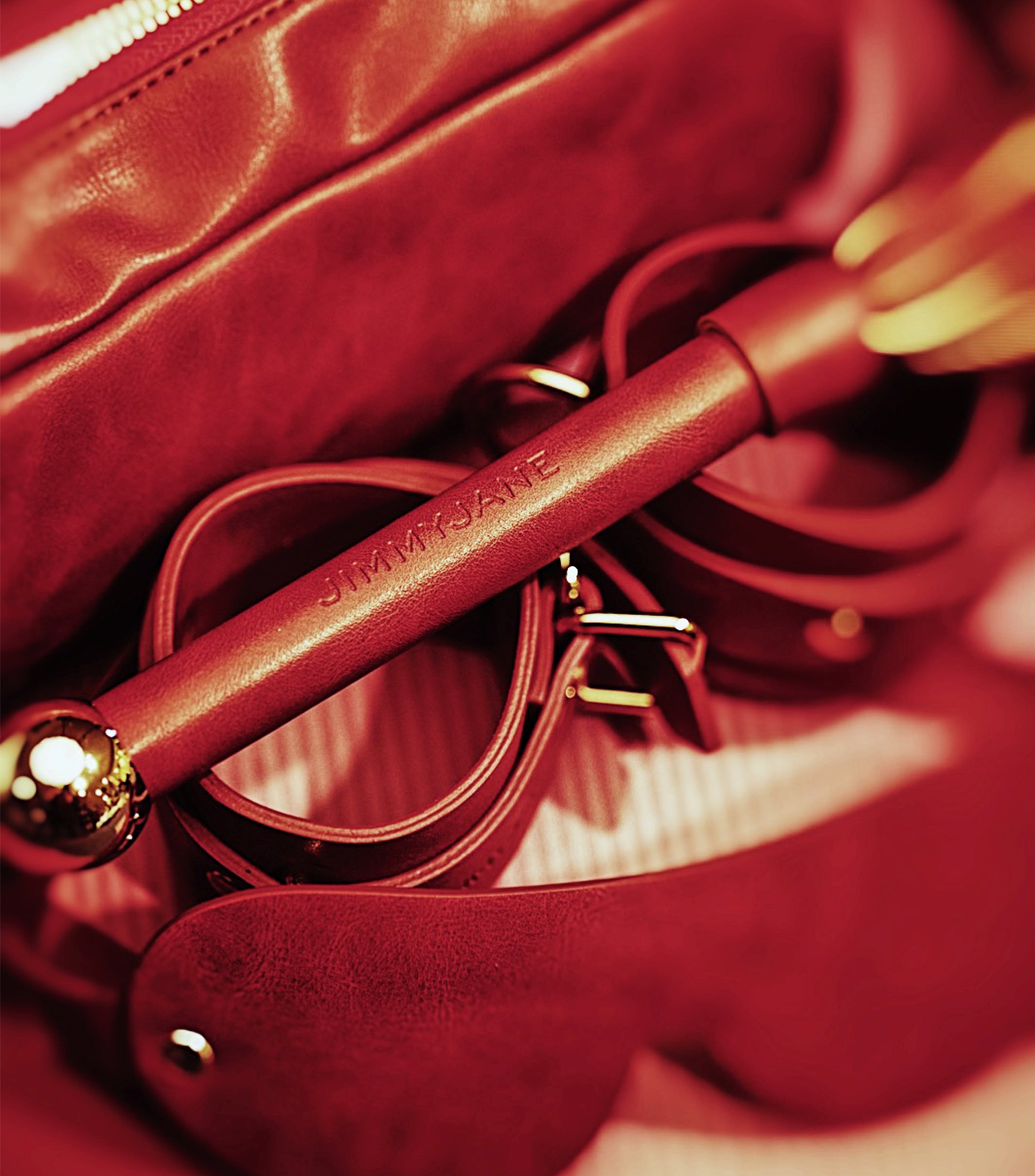 Red handbag with a gold handle and 'JIMMYJANE' branding.