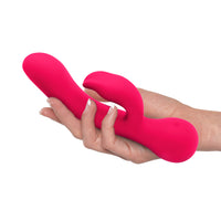 Top-facing silicone rabbit vibrator pink in a white woman's palm