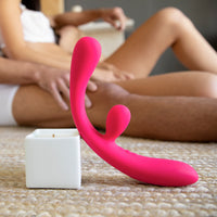 Rabbit Vibrator Pink Color Reflexx 3 leaning against Afterglow candle