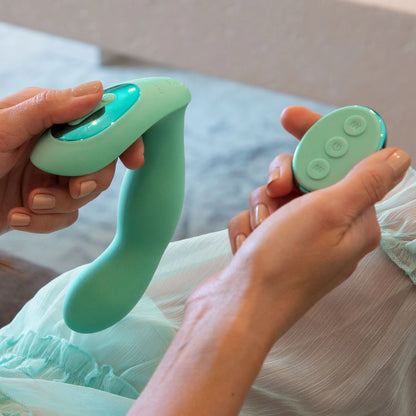 A person holds the JIMMYJANE® Pulsus™ G-Spot, which has dual motors, and its matching three-button remote control.