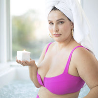 White female model holding Afterglow massage oil candle