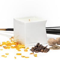 Velvet Spice scented Afterglow massage oil candle sitting on table surrounded by ingredients