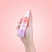 Self + Jimmyjane Intimate Accessory Cleaner 4.0 fl. oz. bottle being held in models hand on a pink background