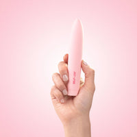 Self + Jimmyjane vibrating slimline massager in light pink in models hand with pink background